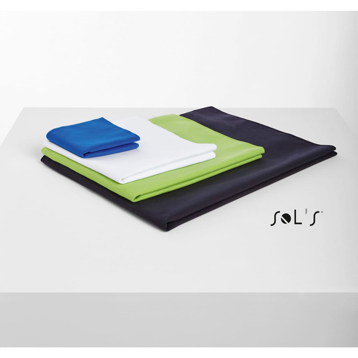 Four towels in varying sizes, featuring blue, white, green, and black colours, stacked on a surface.