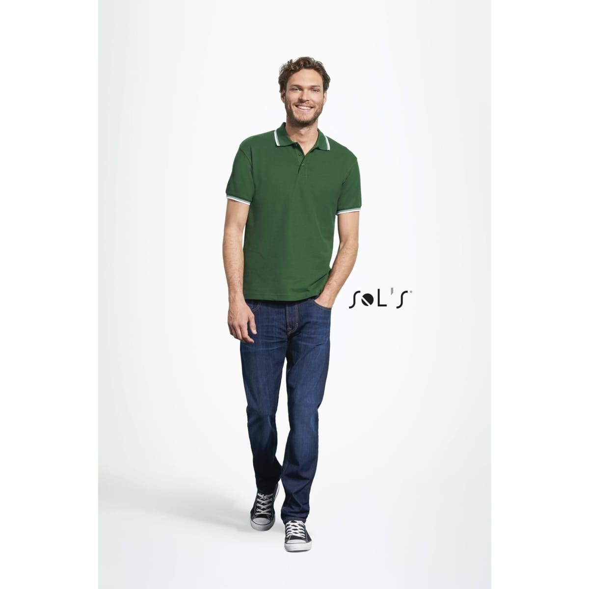 A green polo shirt made of 100% ring spun cotton, worn by a man with a casual outfit. The shirt features a logo.