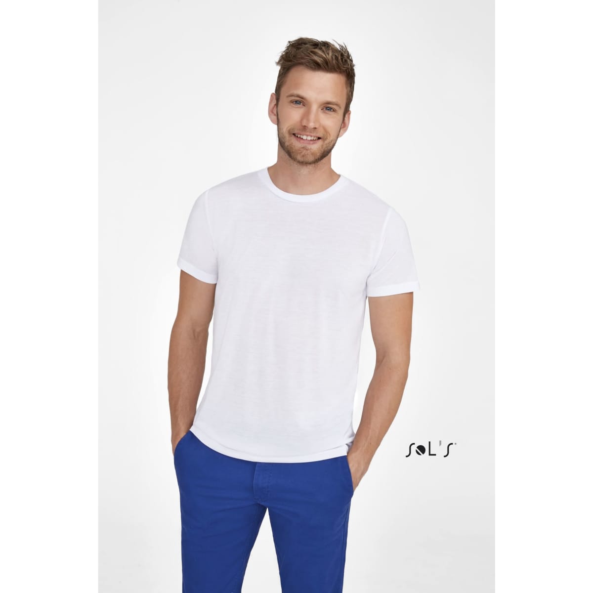 A unisex round collar white T-shirt displayed on a smiling man, paired with blue trousers. The shirt has a logo.