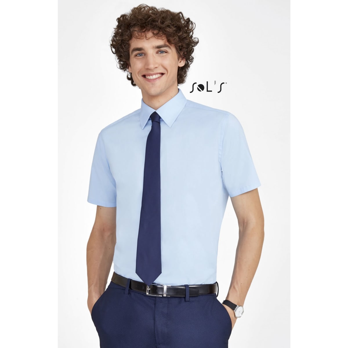 A light blue short sleeve men's shirt, paired with a navy tie and dark trousers, featuring a logo.