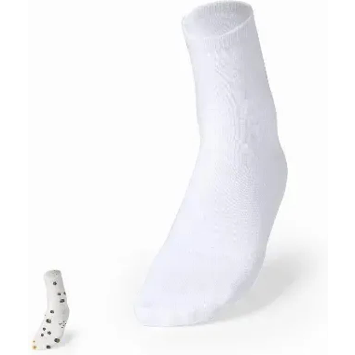 A pair of white socks with a single patterned sock displayed beside them. The patterned sock features black dots.