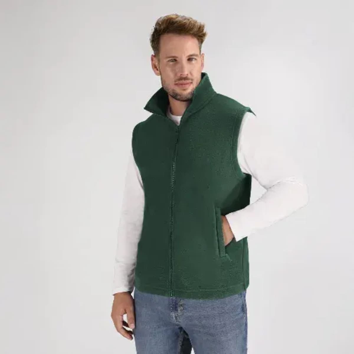 A green fleece vest featuring a high collar, worn over a long-sleeve white shirt. The vest has a zipper and no sleeves.