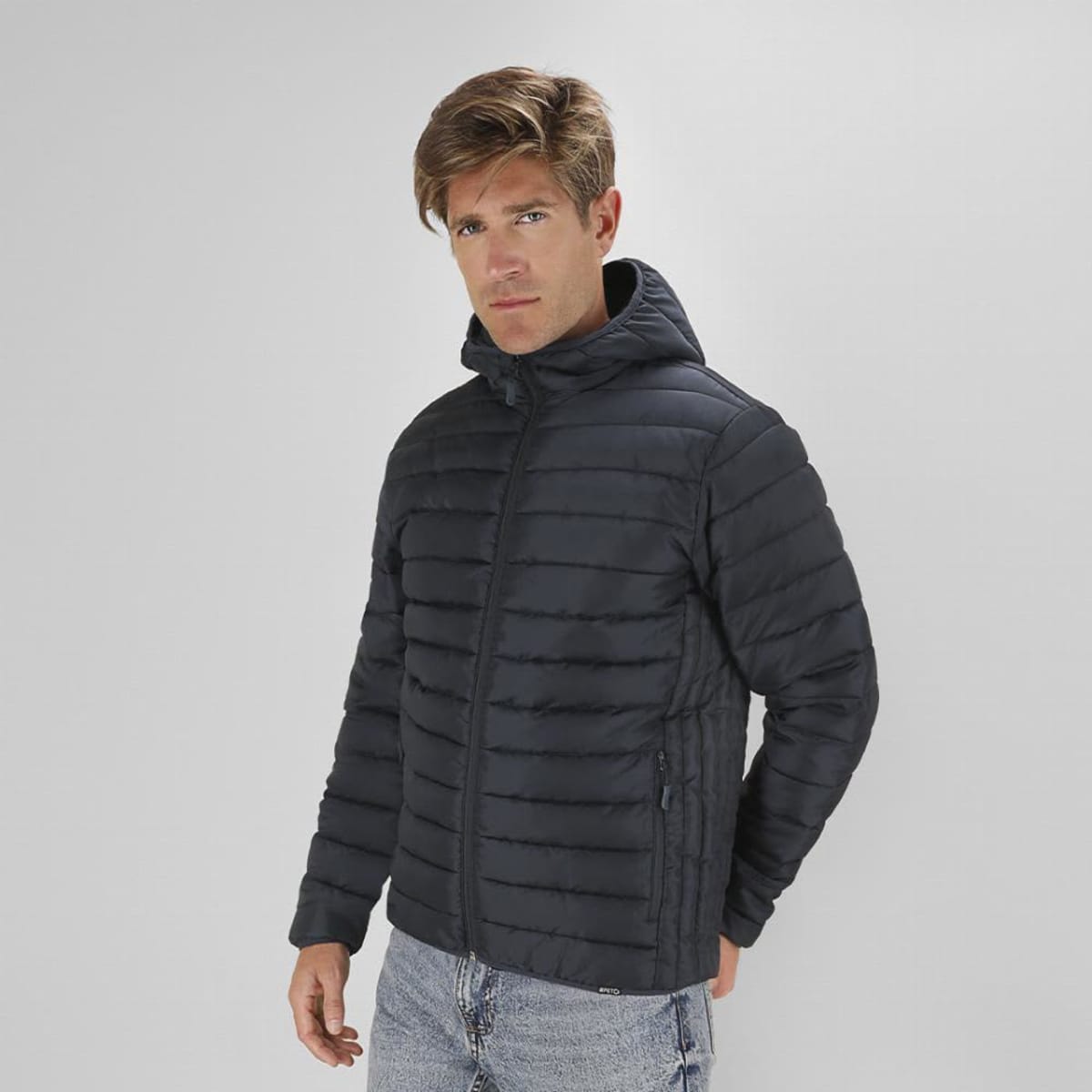 A puffer jacket in dark blue with a hood, featuring a zip closure and horizontal quilted design.