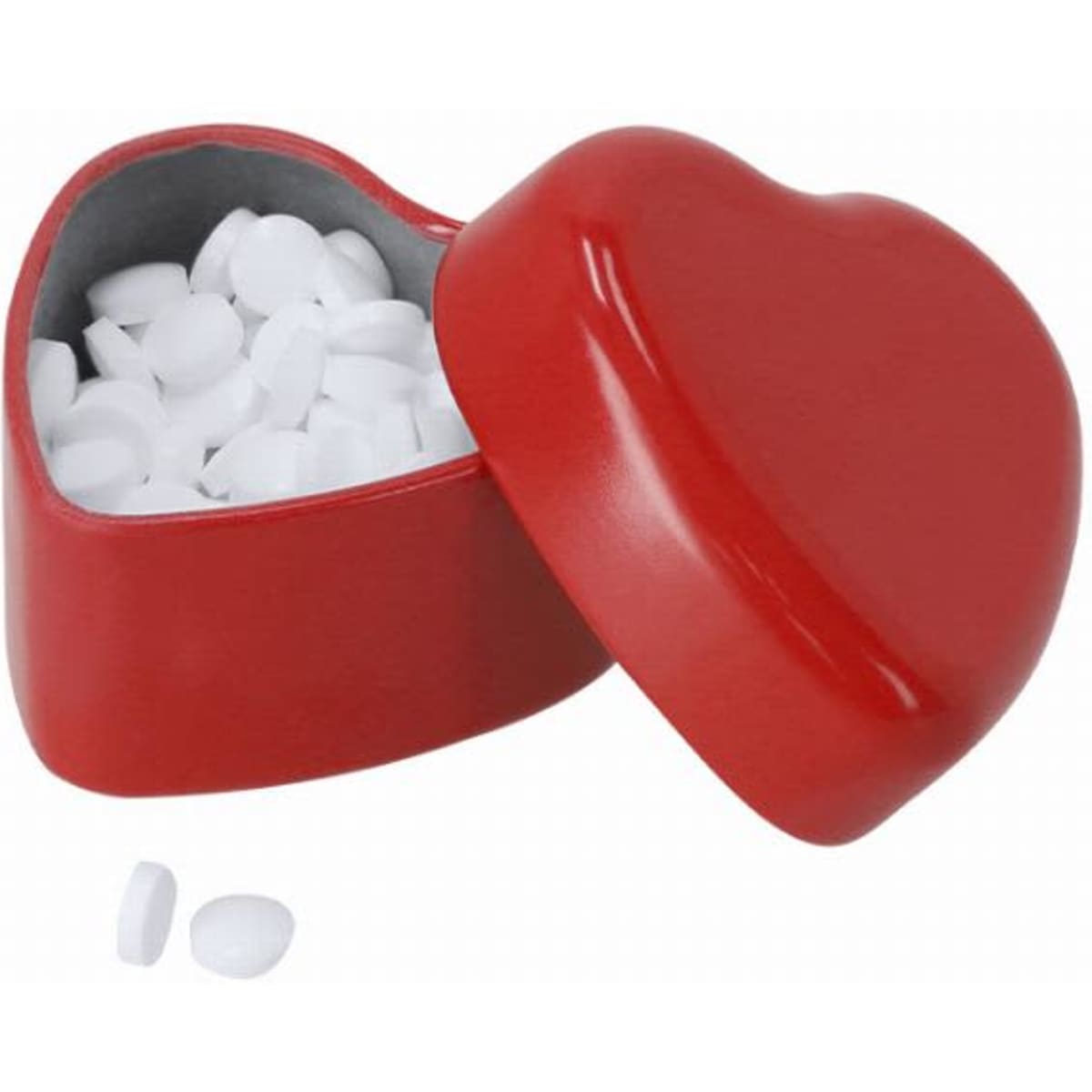 A red heart-shaped box with a lid, filled with small white candies. Two candies are placed beside the box.
