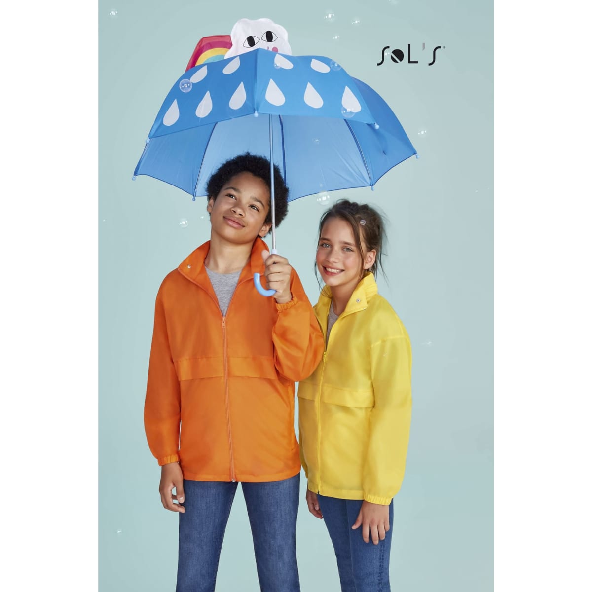 A children's raincoat in orange and yellow, made of 100% nylon, with a water-repellent hood. An umbrella is also featured.