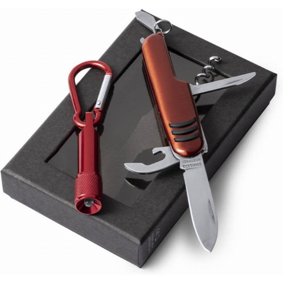 A multi-tool knife in a red and silver finish, accompanied by a red carabiner and a flashlight, presented in a black box.