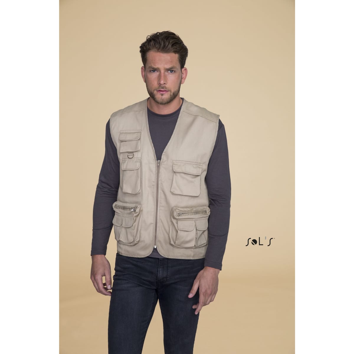 A light beige men's outdoor vest with nine pockets displayed on a model against a neutral background.