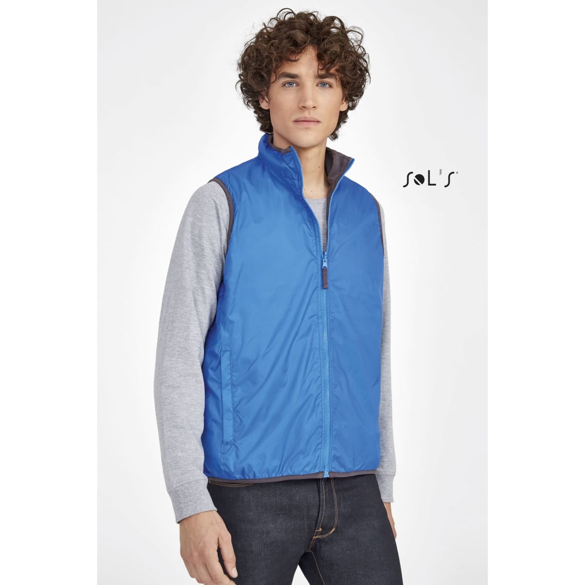 A blue, unisex, reversible vest that is waterproof and windproof. It features a zippered front and has a logo.