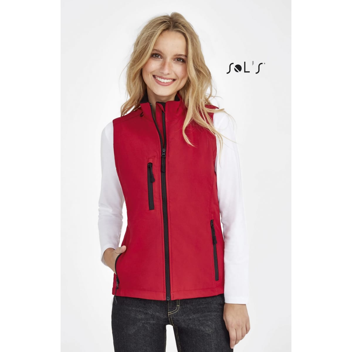 A red women's softshell vest featuring zippered pockets and contrasting black zippers, with a logo on the side.