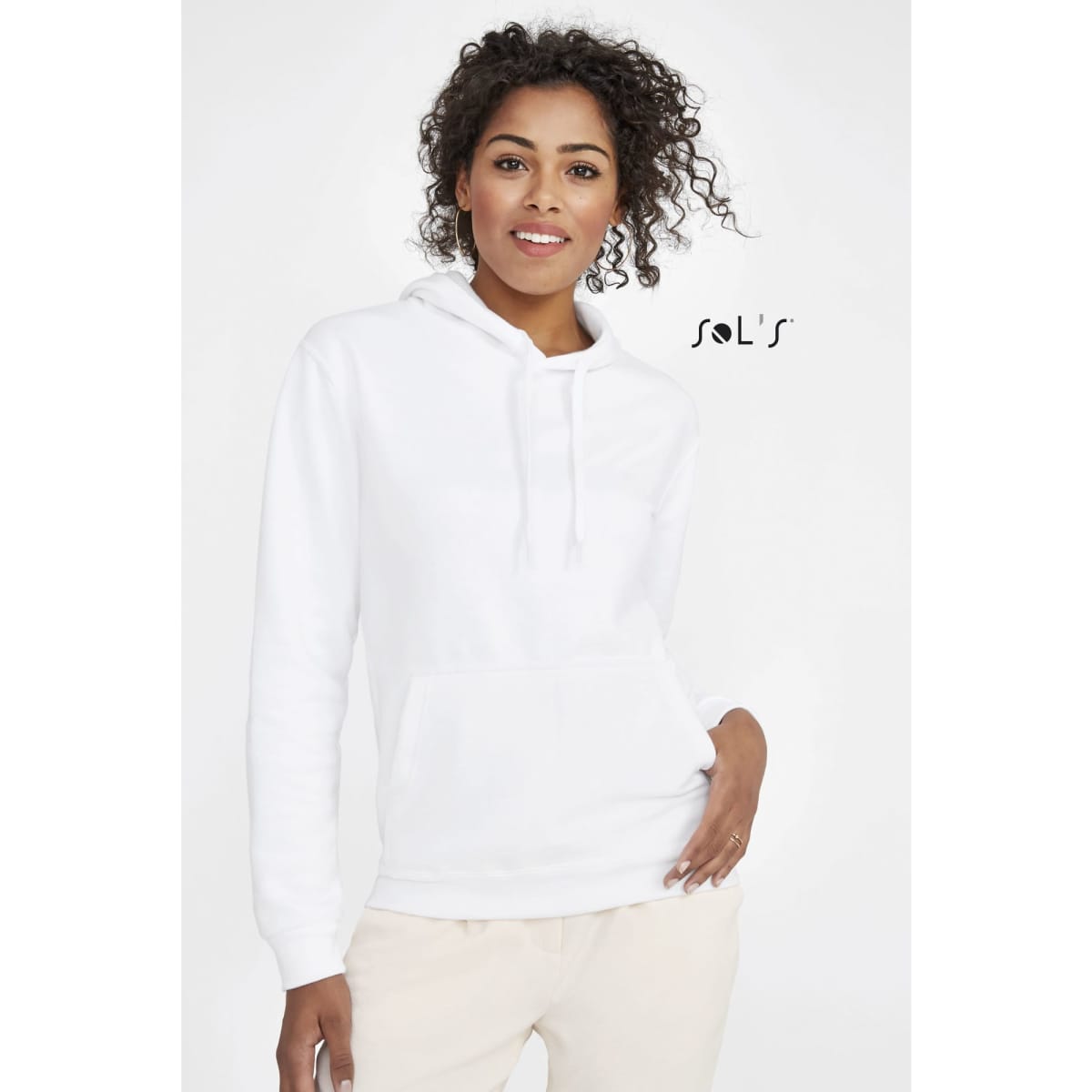 A white unisex hoodie with a fleece lining, featuring a pocket and a hood. The model has curly hair and is smiling.