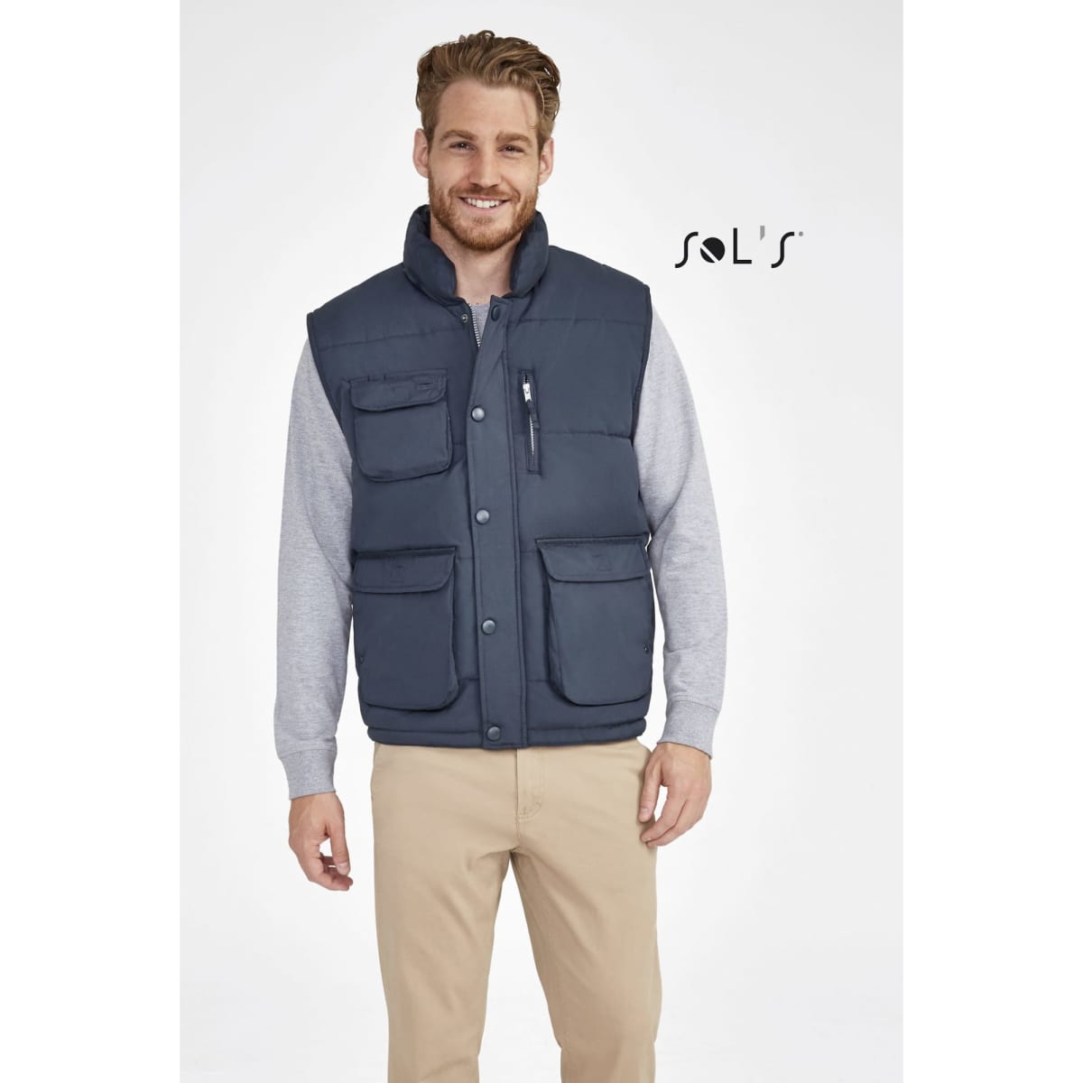 A navy vest featuring multiple pockets and a peach skin exterior feel, displayed on a model.