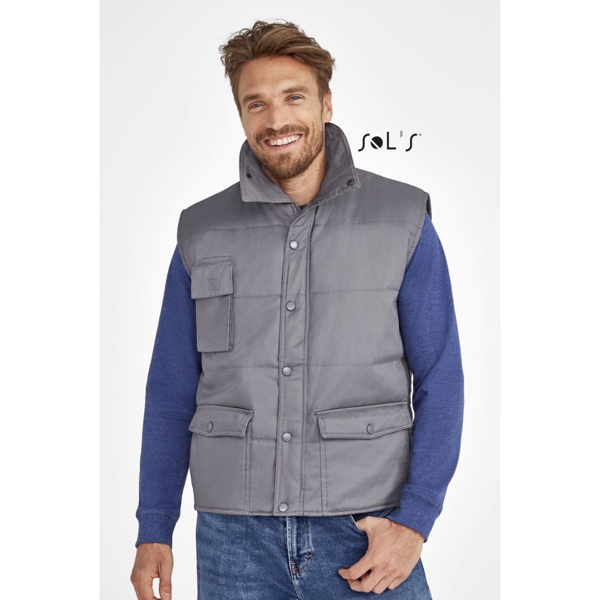 A grey vest with multiple exterior pockets, featuring a collar, worn over a blue long-sleeve shirt.