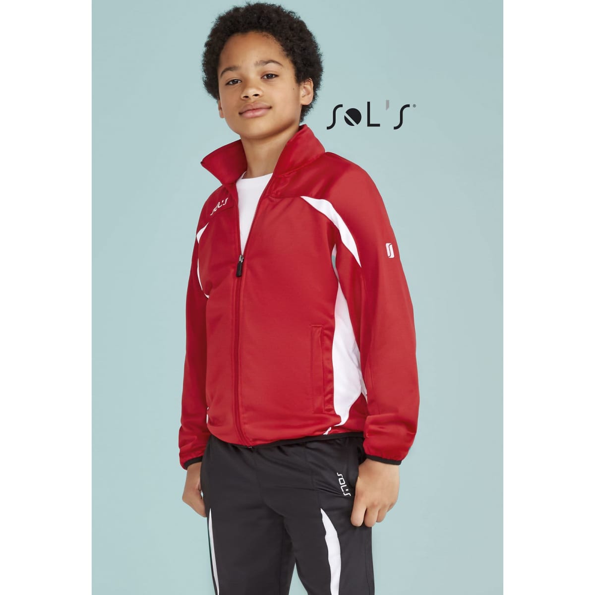 A red tracksuit jacket with white accents, paired with black tracksuit bottoms. The outfit has a logo on it.