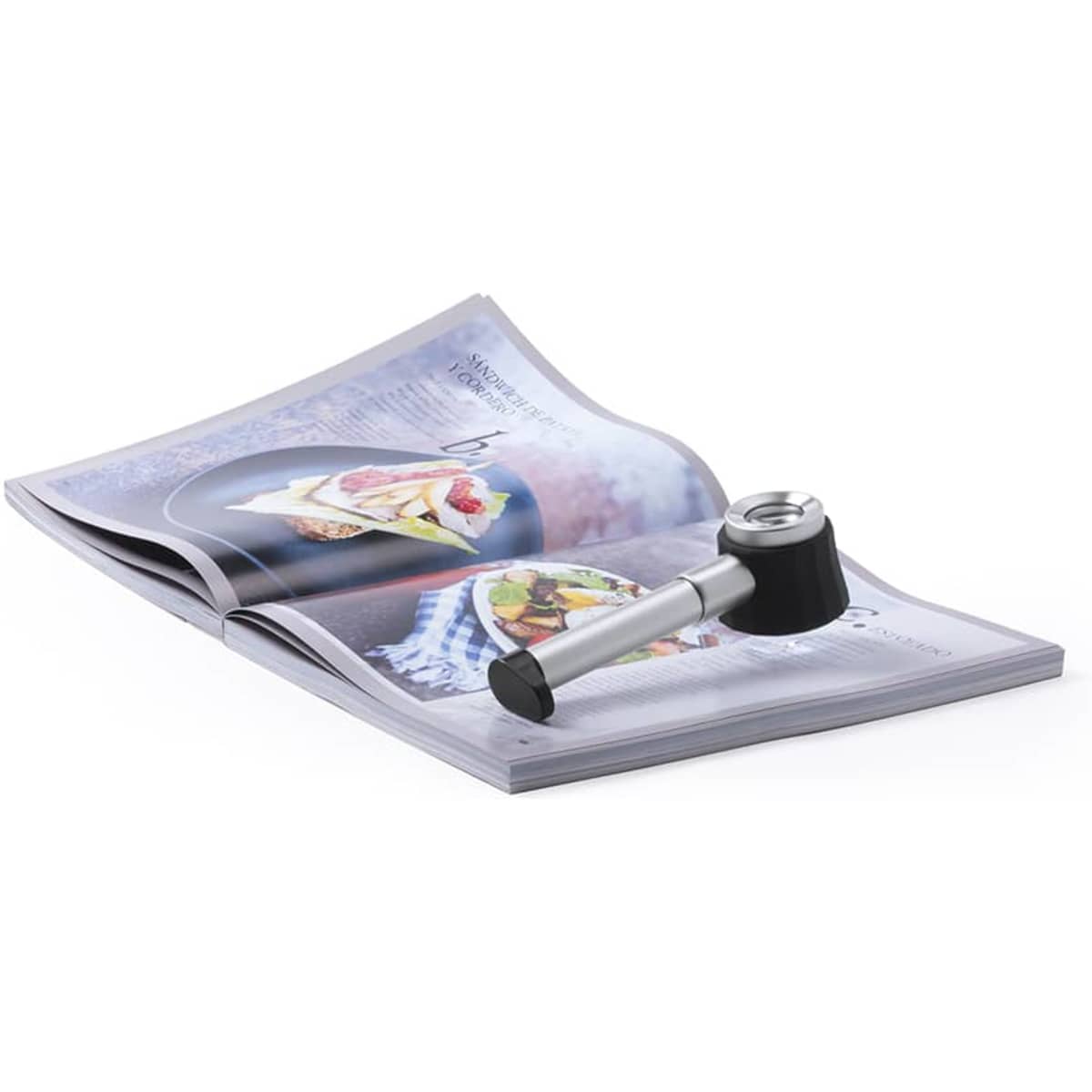 A magnifier in silver and black resting on an open magazine page filled with images of food.