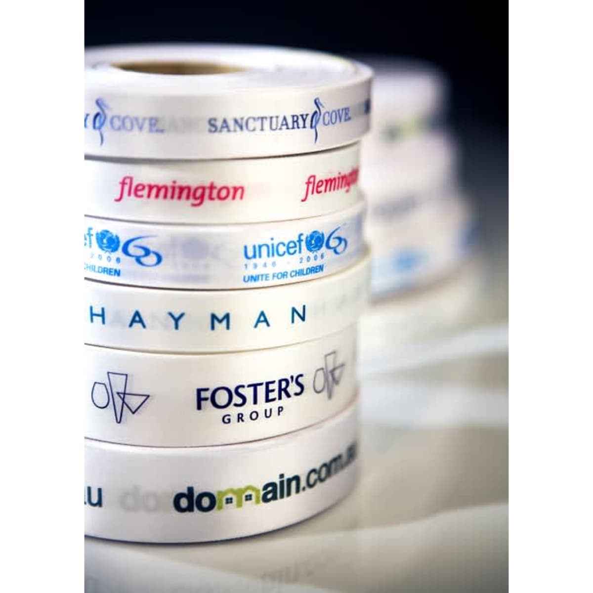 A stack of white ribbons featuring various logos and text in different styles and colours.