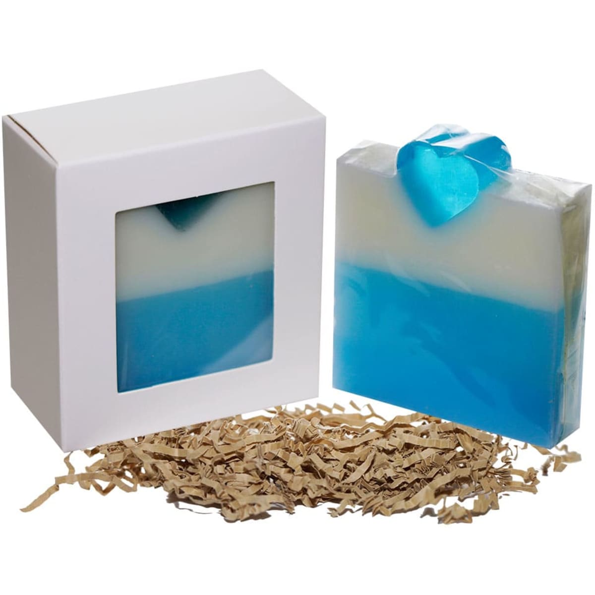 A blue and white soap bar with a heart-shaped embellishment, displayed in a white box with a clear window and decorative filling.