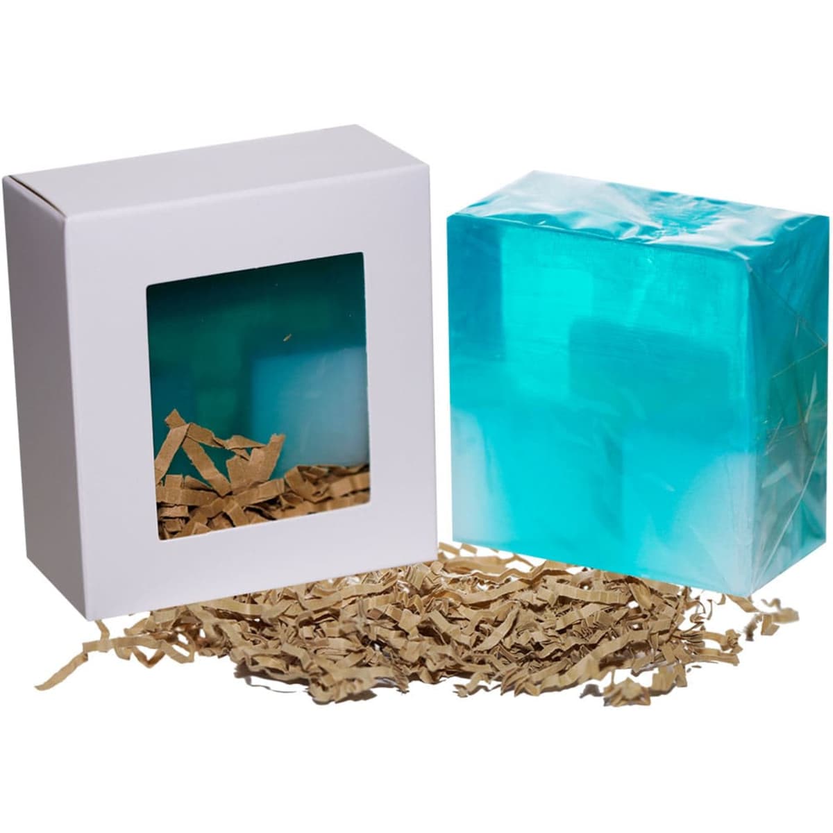 A boxed product featuring a transparent turquoise item and brown shredded paper. The box has a clear window and a logo.