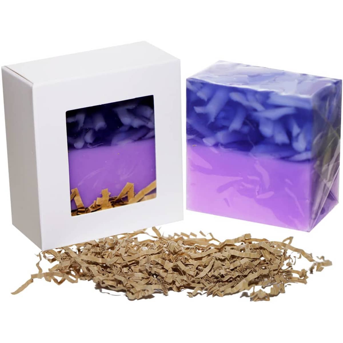 A lavender fragrance soap block in a white box, featuring purple and violet layers, alongside shredded paper packaging.