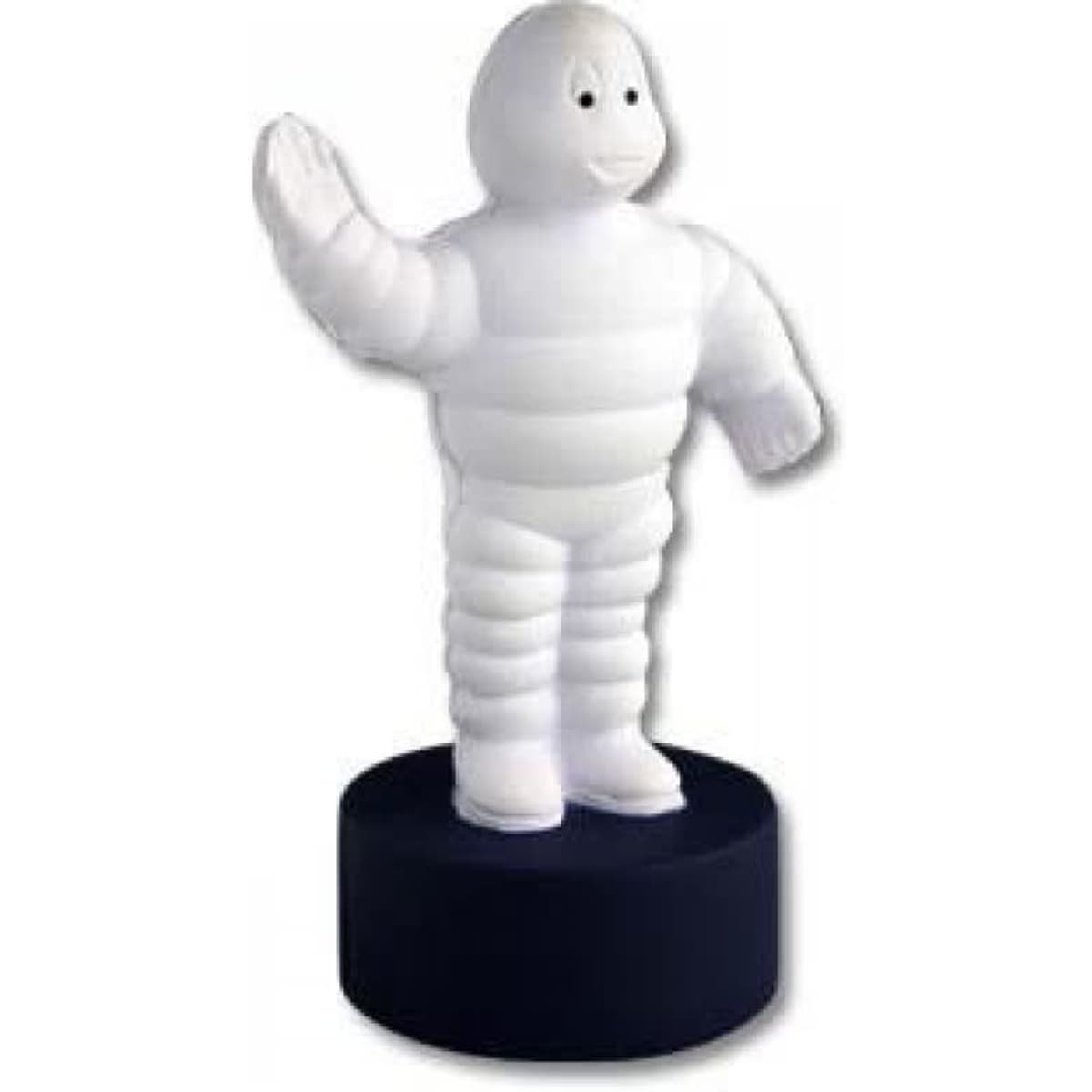A white stress toy shaped like a cartoon figure, standing on a black base, with a friendly smile and waving hand.