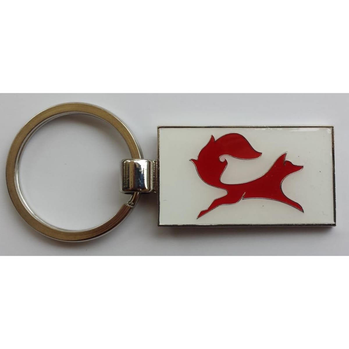 A silver keyring featuring a red soft enamel fox design on a white background, showcasing a polished finish.