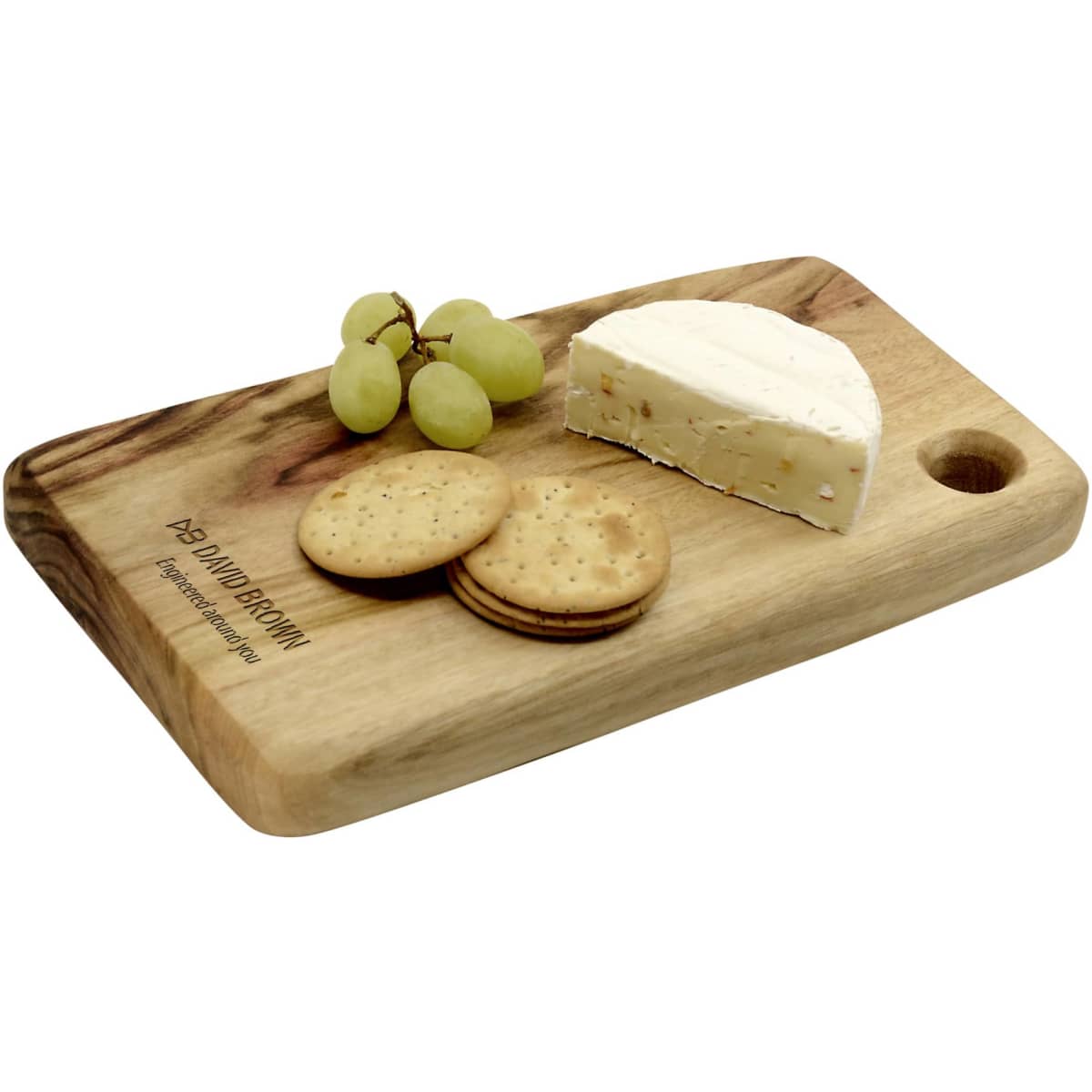 A wooden cheese board with a handle features crackers, grapes, and a wedge of cheese. The board has a branding logo.