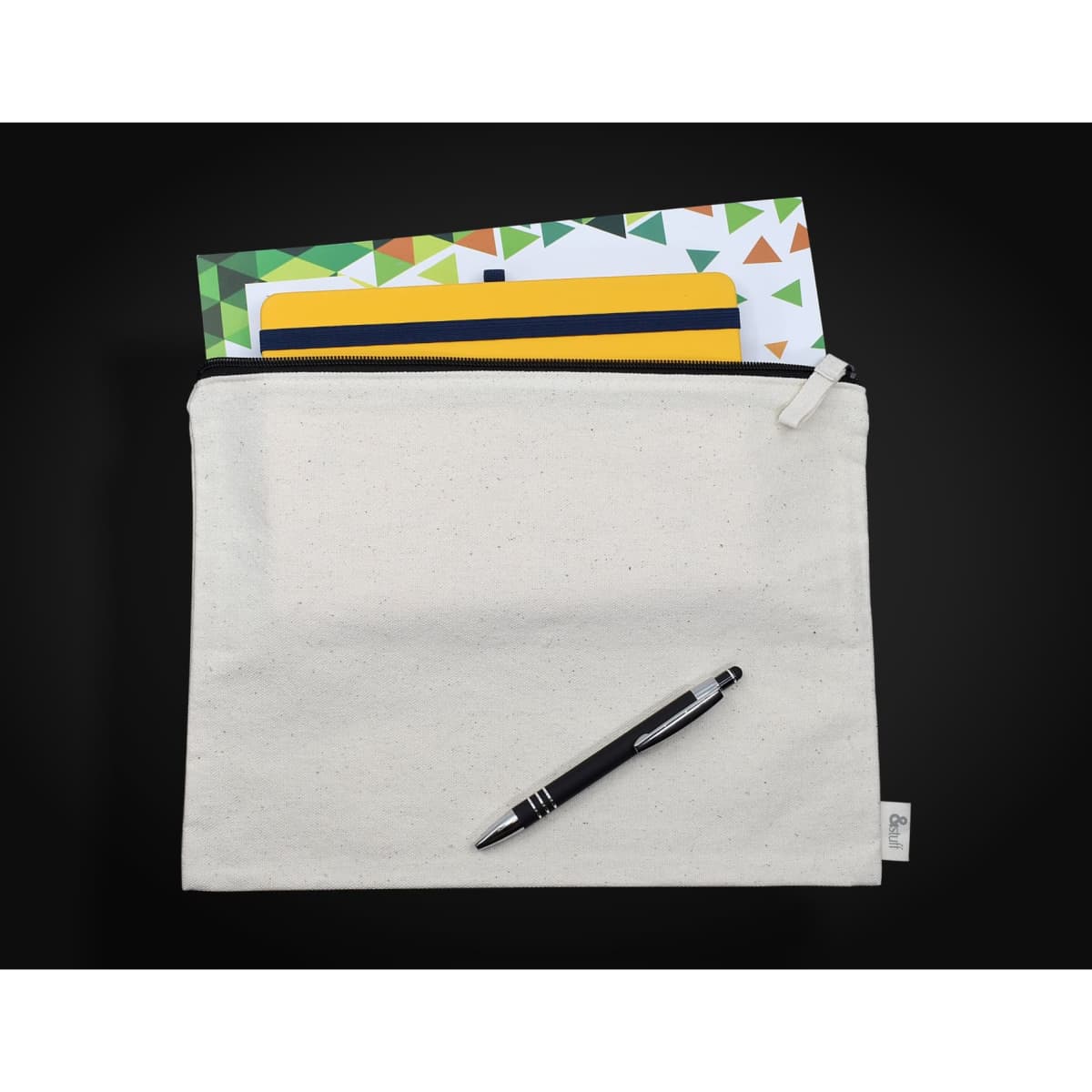 A cream-coloured conference bag featuring a zip closure, with a pen and assorted notepads visible inside.