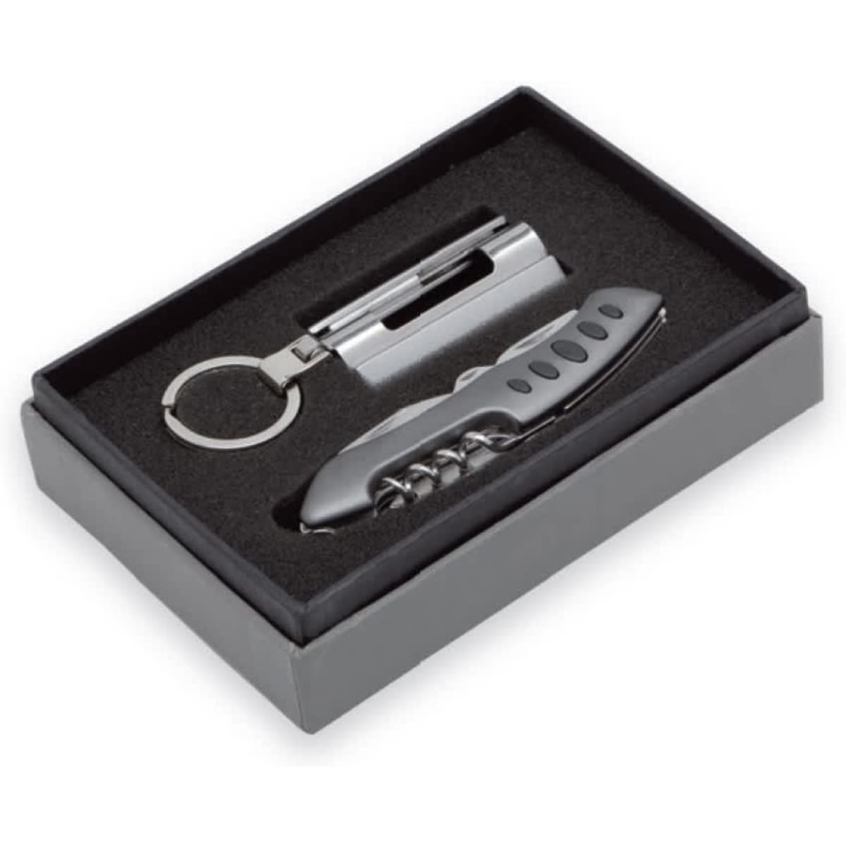 A black gift box containing a silver multi-tool and keyring accessory, presented on a plush interior.