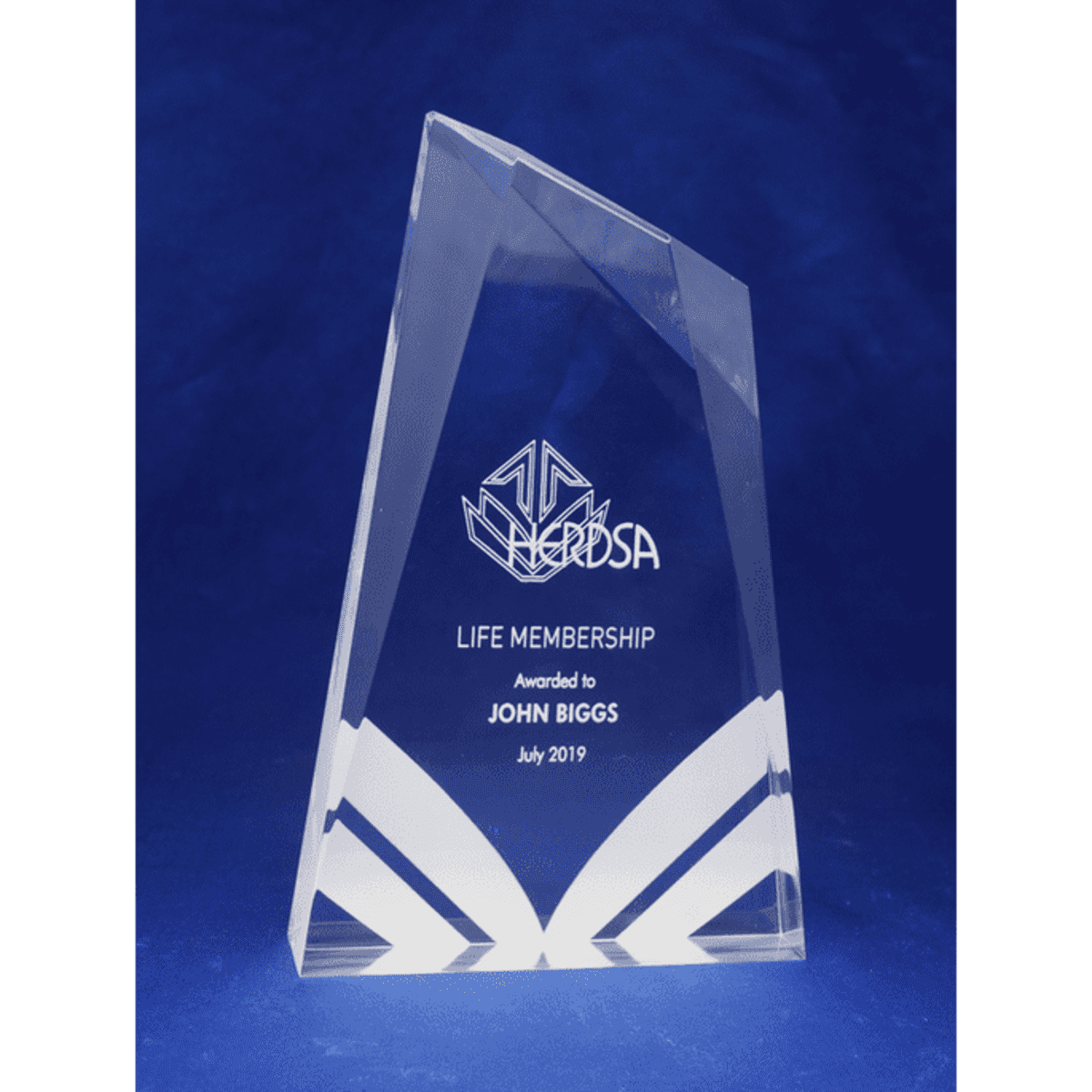 A clear acrylic award with a geometric design, featuring the text "Life Membership" and a logo.