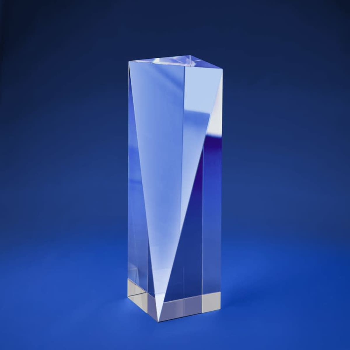 A V-shaped solid optical crystal award with clear surfaces, set against a blue background.