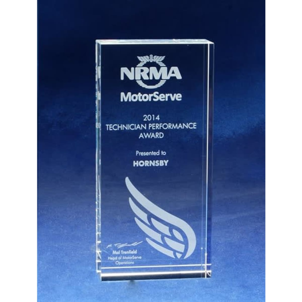 A clear optical crystal monolith award featuring etching, showcasing the NRMA logo and performance award details.