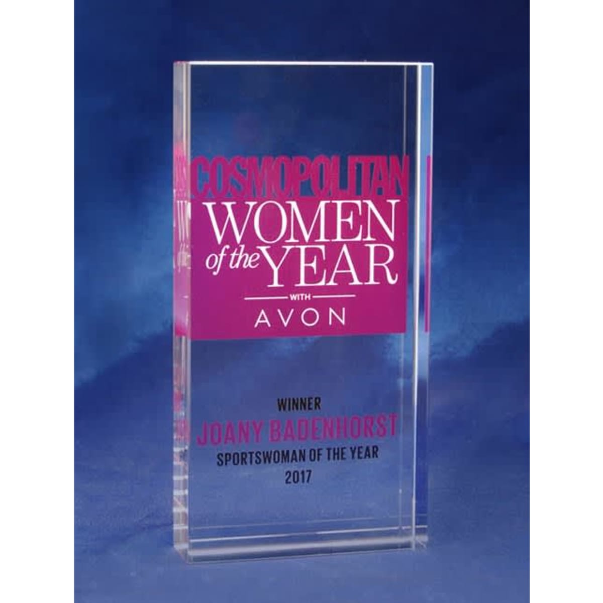 A clear optical crystal award with a vibrant pink printed background featuring text for "Women of the Year".