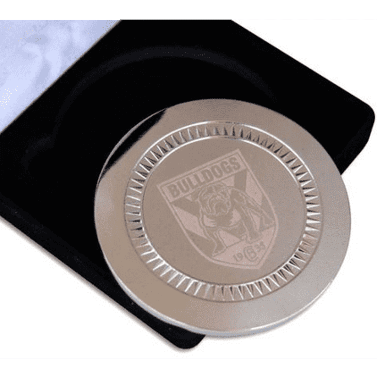 A silver medallion featuring an engraved logo, presented in a black velvet case.