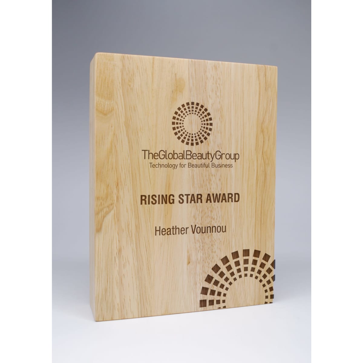 A wooden block award with a polished finish, featuring text engraving and a logo in a circular design.