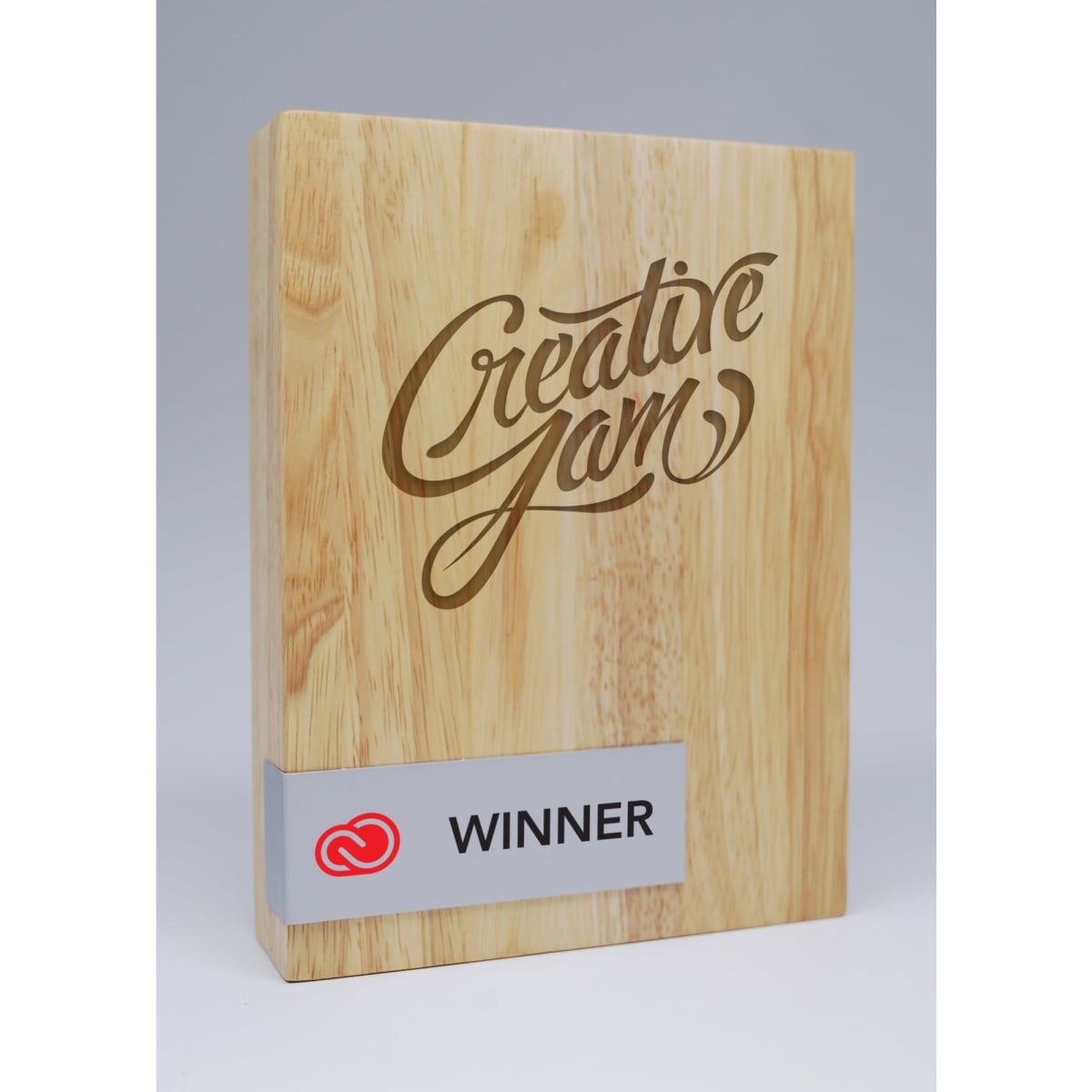 A wooden block award featuring a printed metal plate. It has a natural wood finish with script lettering and a logo.