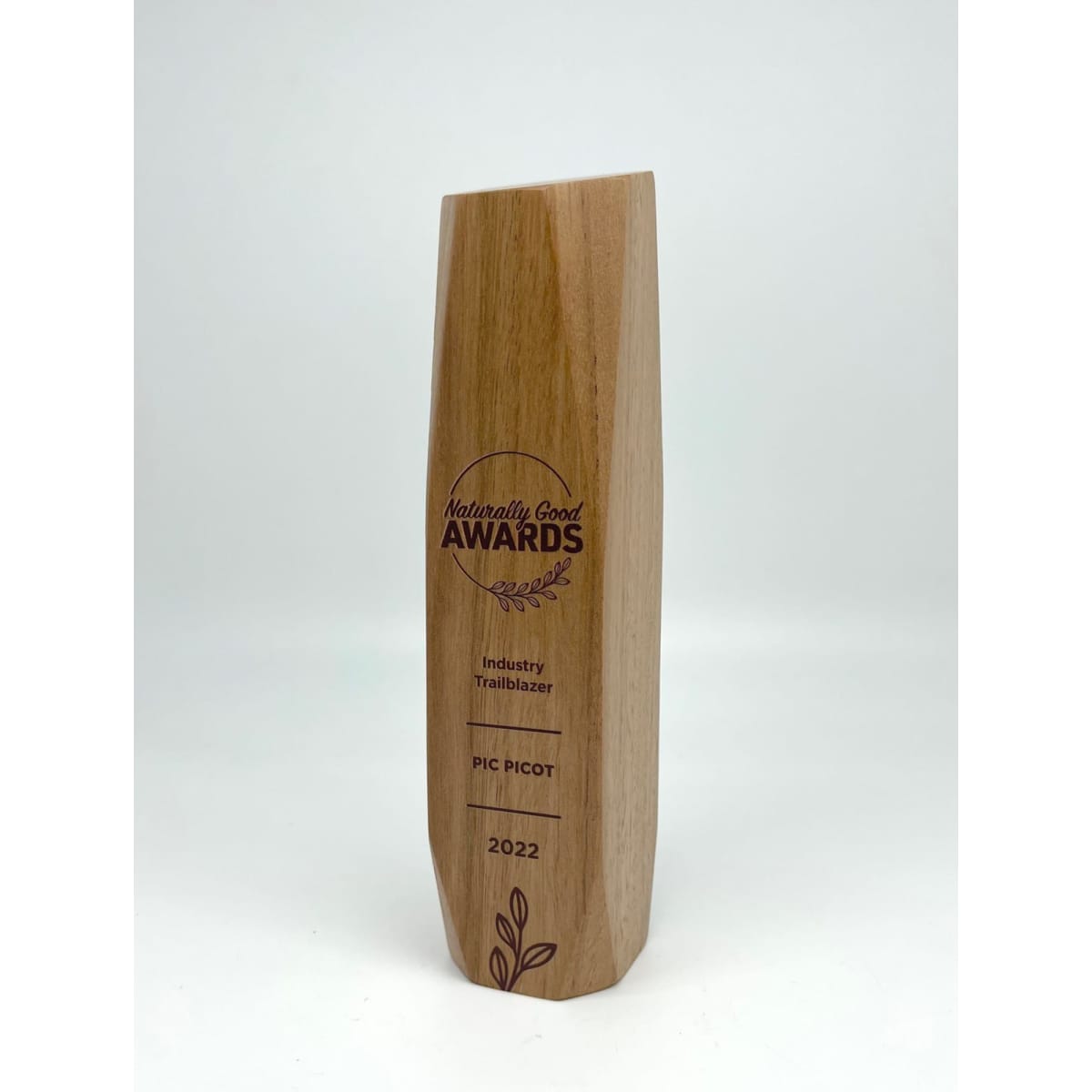 A wooden trophy with a sleek design, featuring a logo and engraved text in brown.