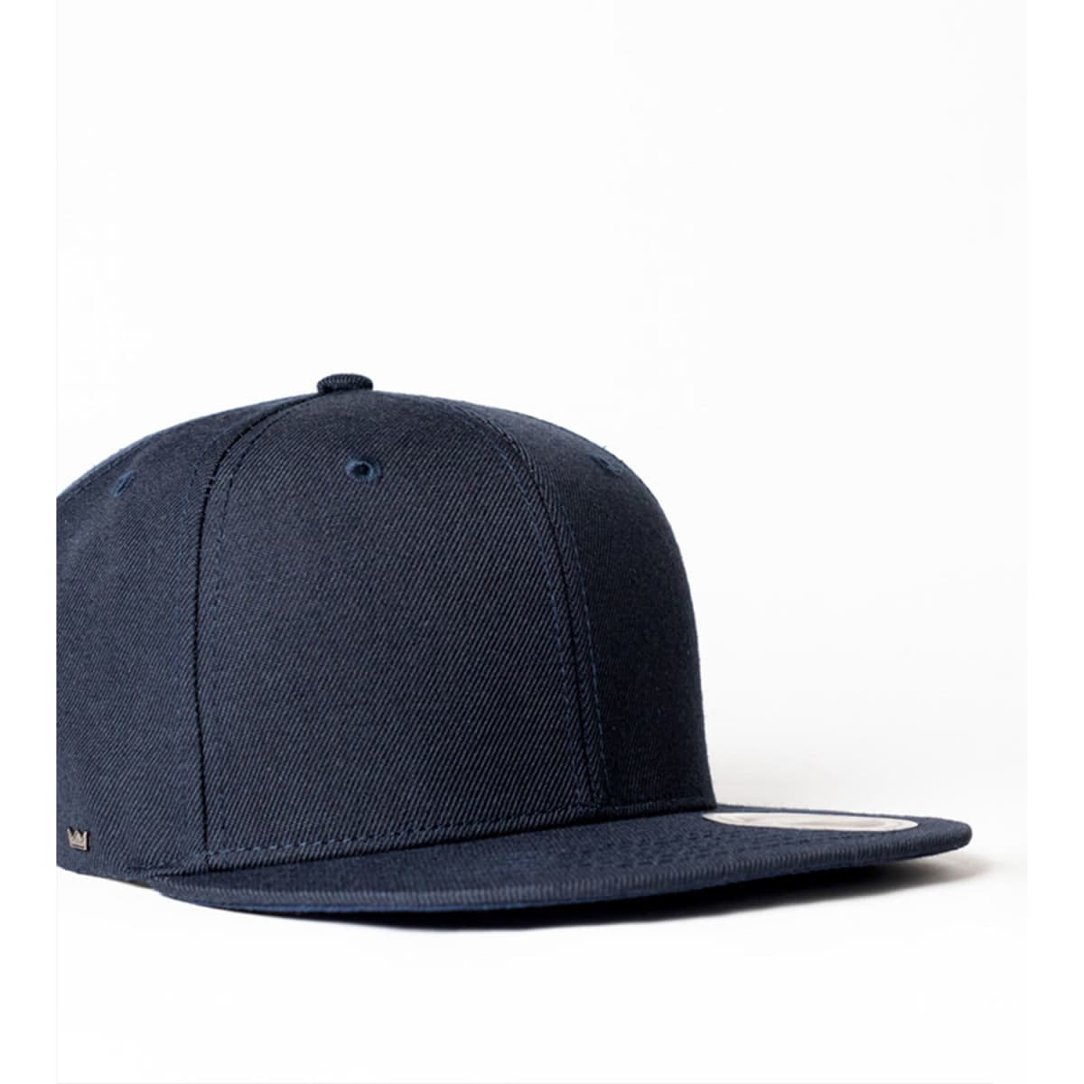 A navy blue cap with a flat brim and a logo on the side. The cap is designed for kids.