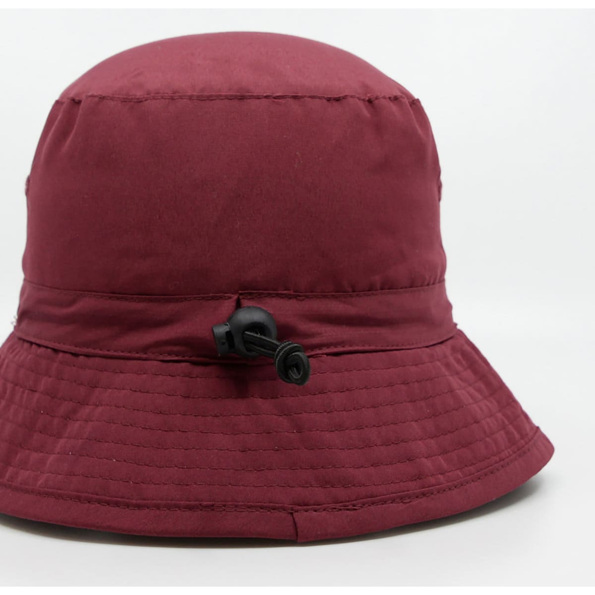 A maroon microfibre bucket hat featuring a drawstring adjustment and a logo on the side.