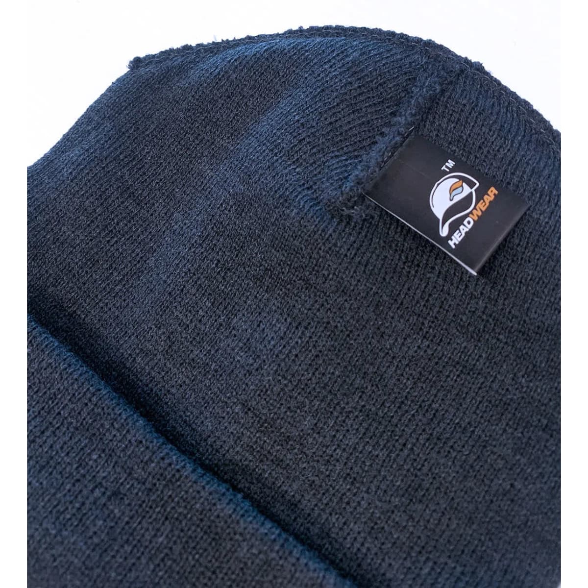 A black beanie with a folded cuff and a branded label on the side.