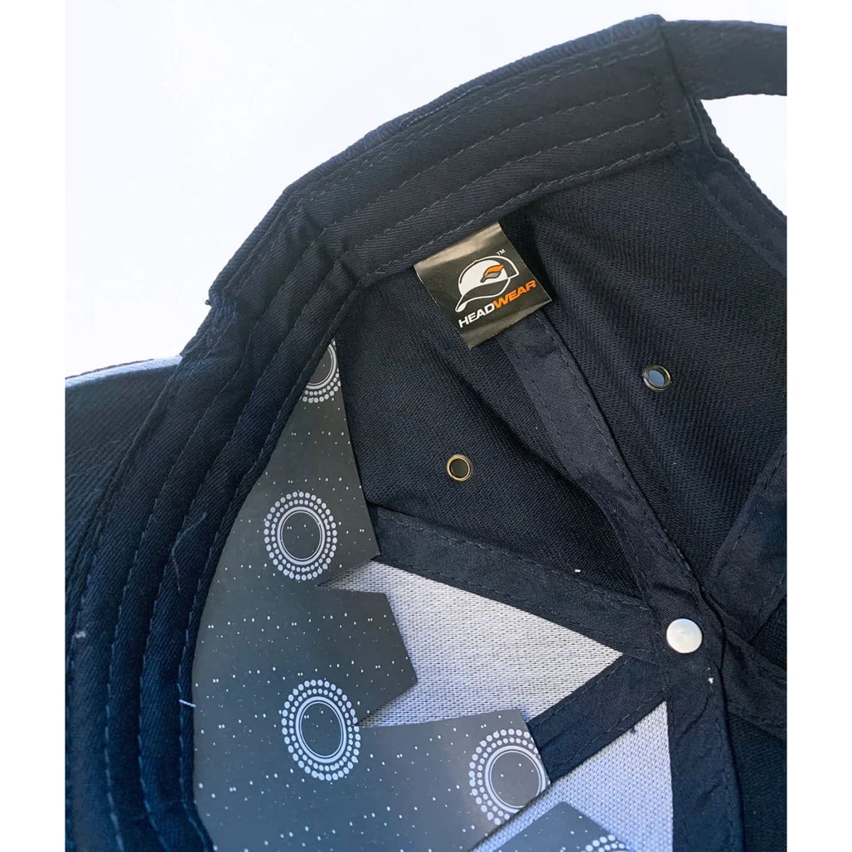 A black cap featuring a logo and a patterned inner lining.