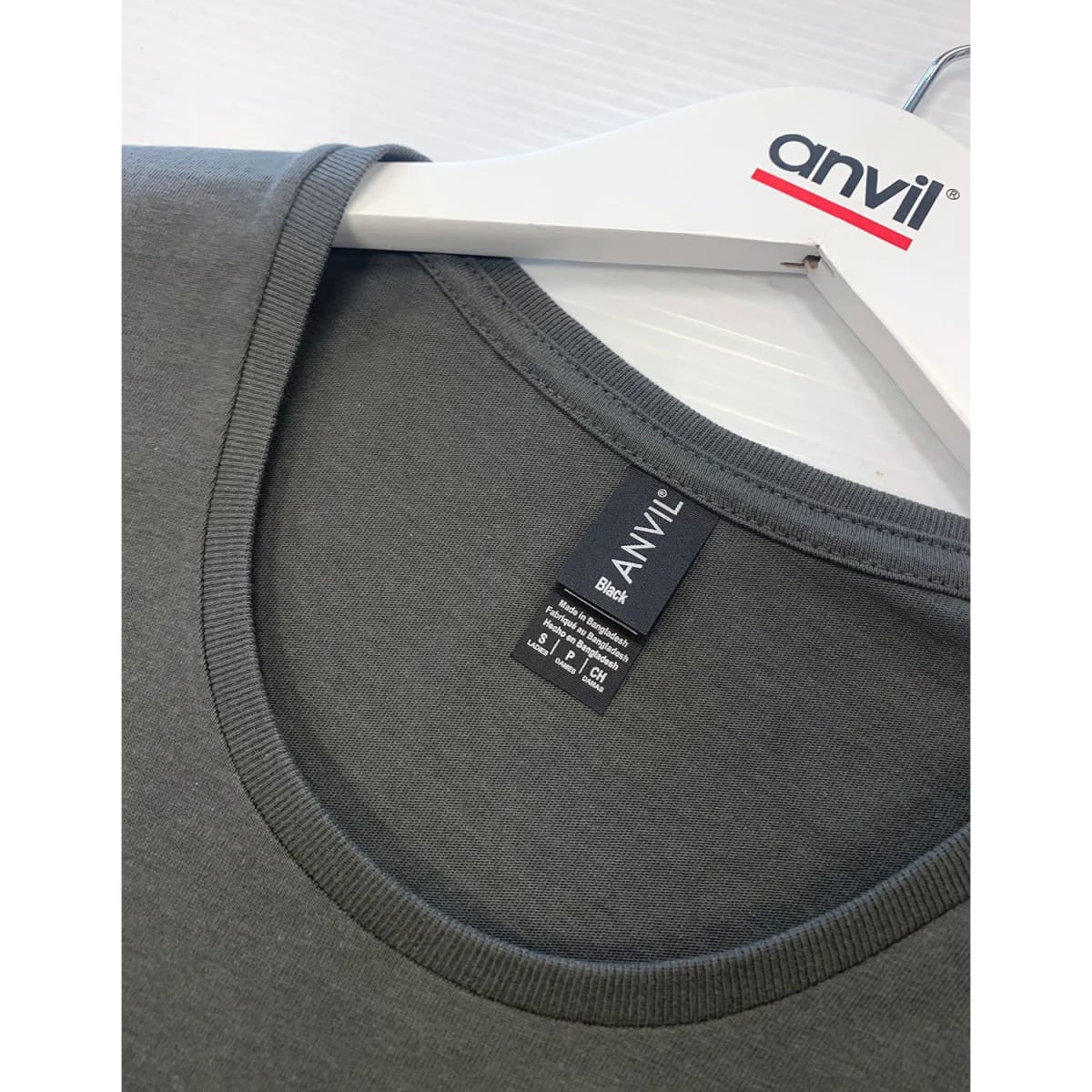 A black T-shirt with a round neckline displayed on a hanger, featuring a logo.