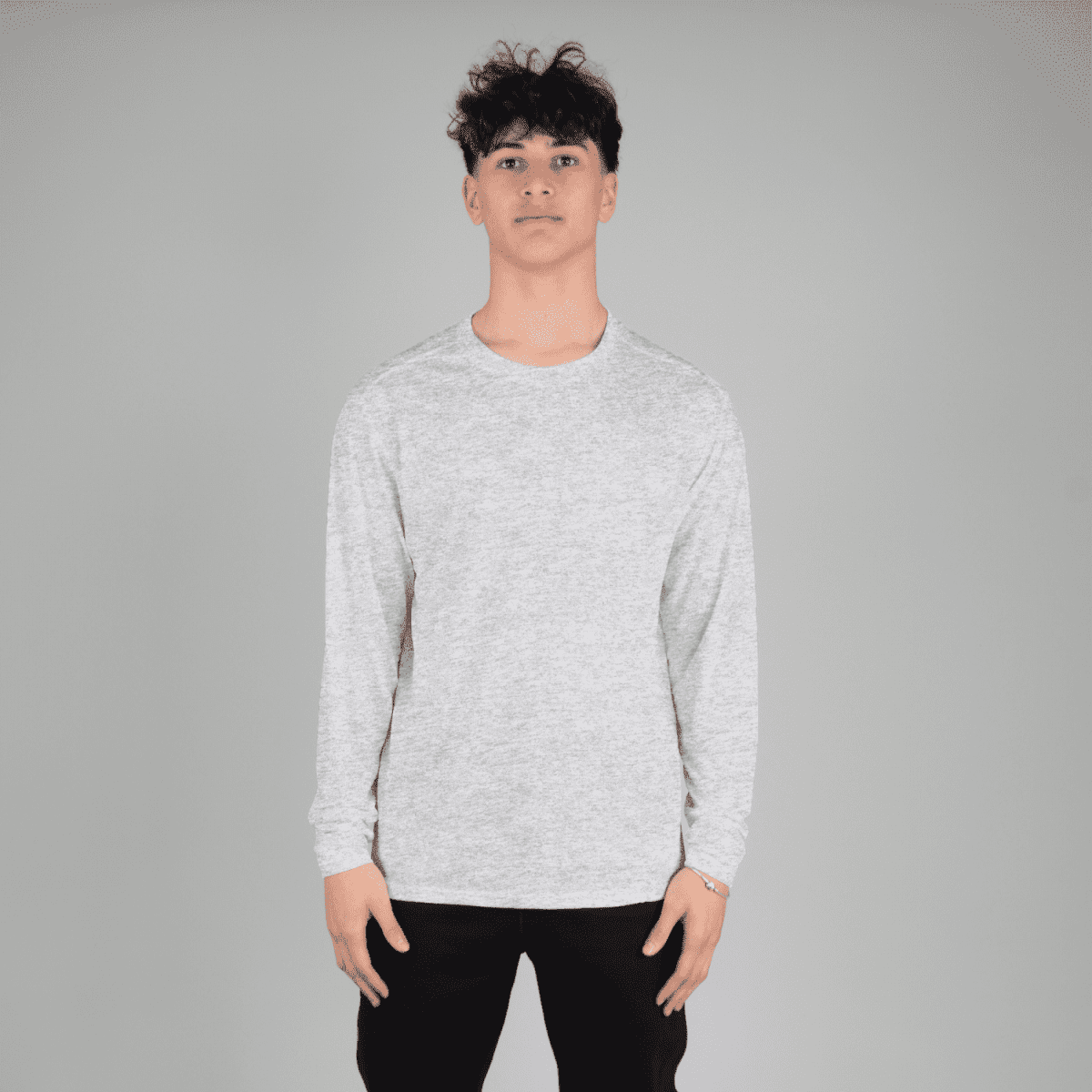 A long sleeve tee in light grey, featuring a simple design and a logo, worn by a model.