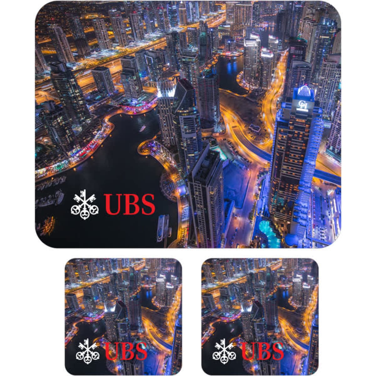 A mouse mat and two coasters featuring a vibrant city skyline in blues and yellows, with a logo on each item.