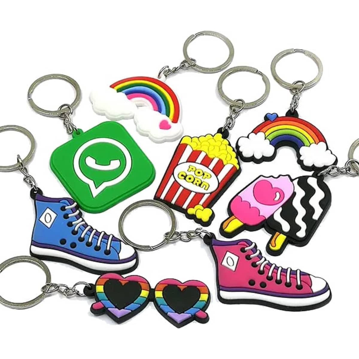A collection of colourful PVC soft keyrings featuring designs like shoes, popcorn, rainbows, and hearts, with silver keyring attachments.
