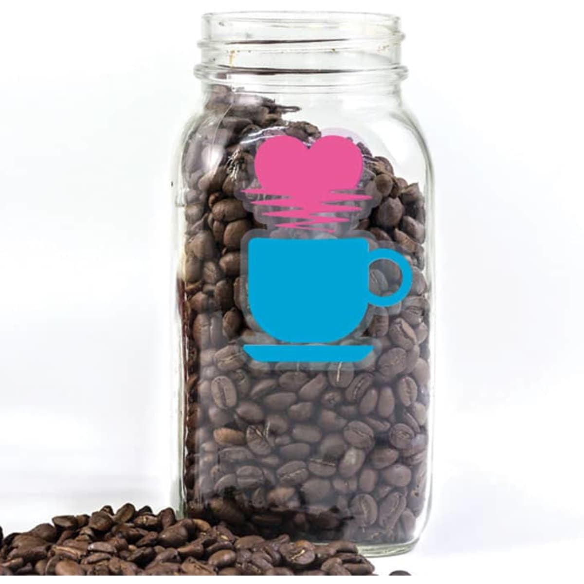 A clear glass jar filled with coffee beans, featuring a blue cup and pink heart sticker.