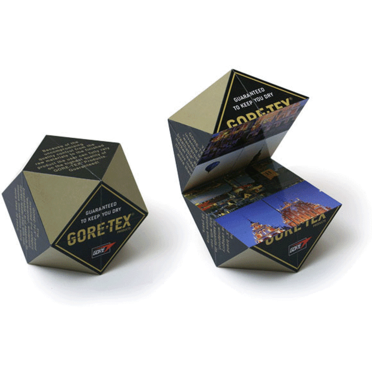 A diamond-shaped promotional cube in black and gold, featuring images on its faces and a logo.