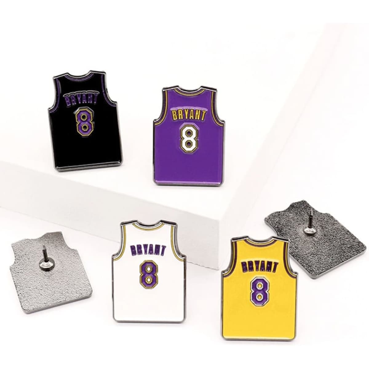 A set of lapel pins featuring basketball jerseys in purple, black, white, and yellow, each with a logo.
