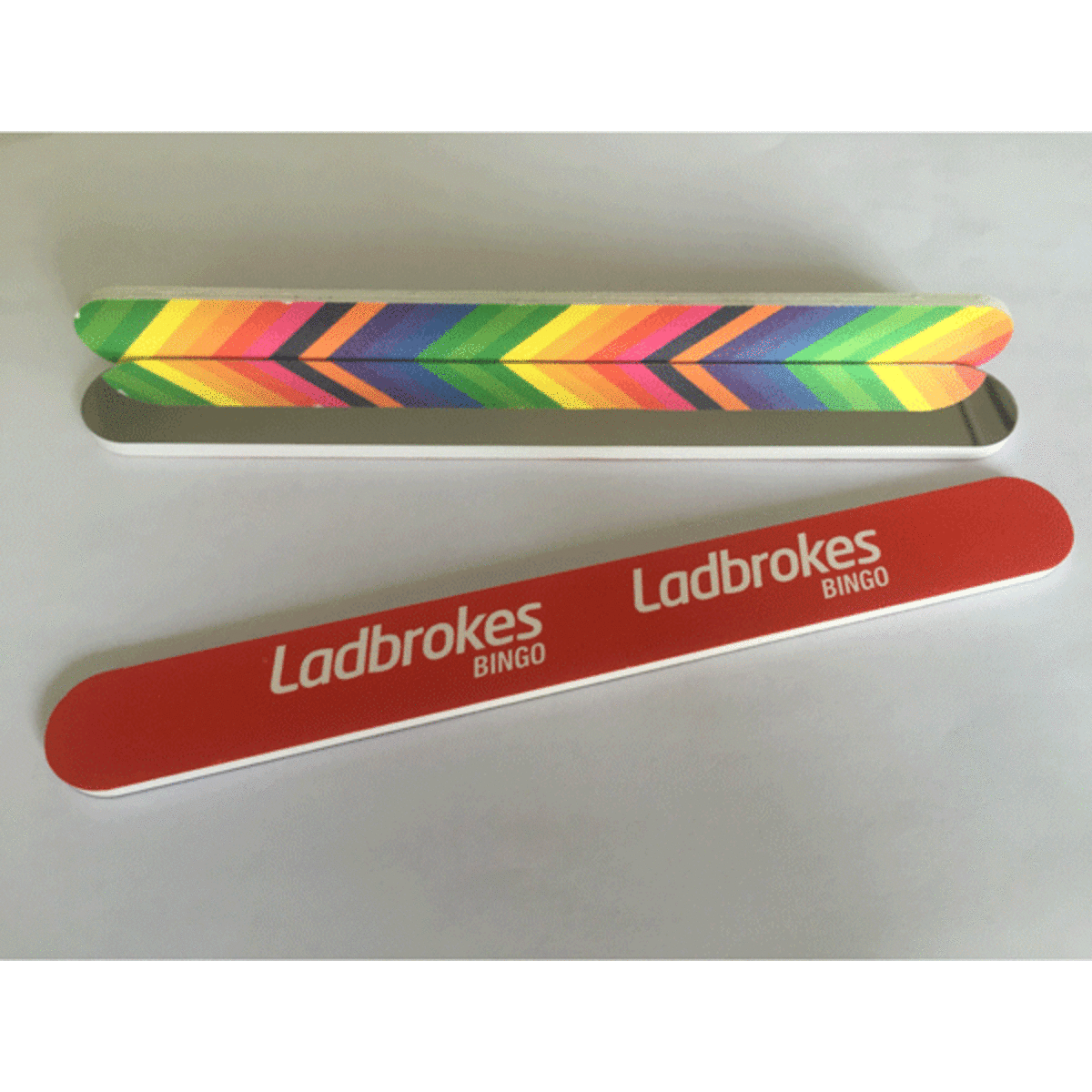 An emery nail file with a mirror, featuring a colourful chevron design and a branded red casing.