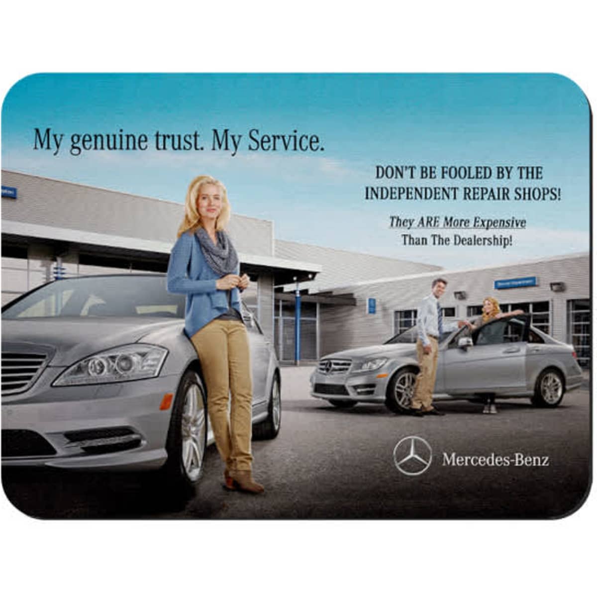 A mouse mat featuring a grey car, a woman posing outdoors, and a logo. The background shows a dealership setting.