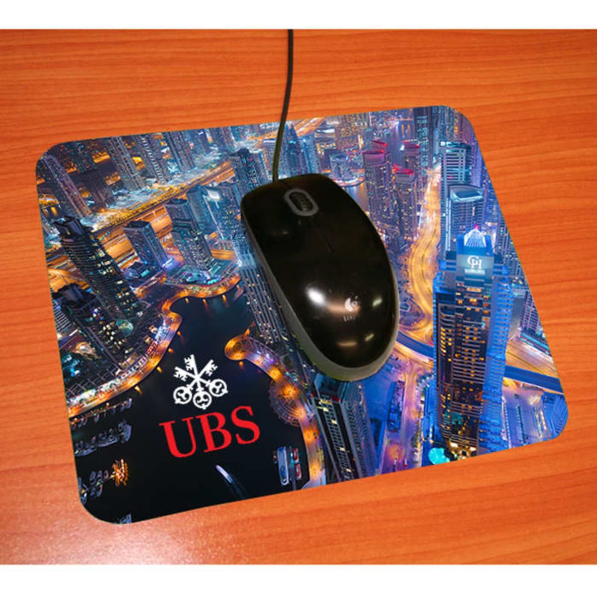 A mouse mat featuring a city skyline design in blue and black, with a logo on the bottom left.