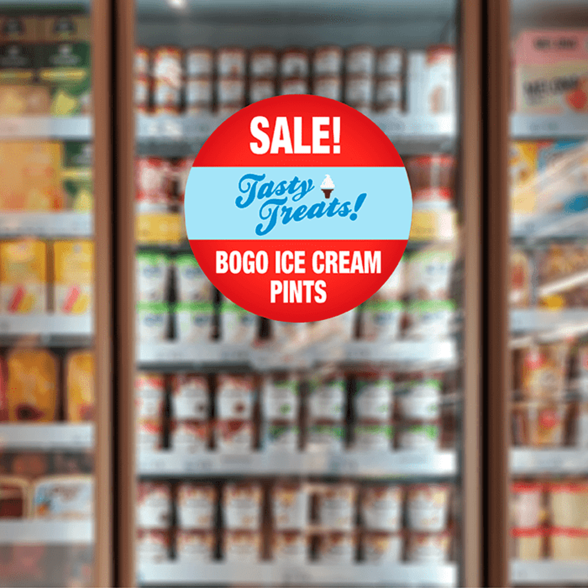 A freezer display filled with various ice cream pints, featuring a circular promotional decal in red and blue.